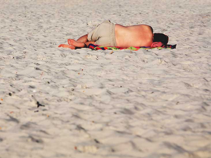 Мокрая девушка на пляже развалилась на песке