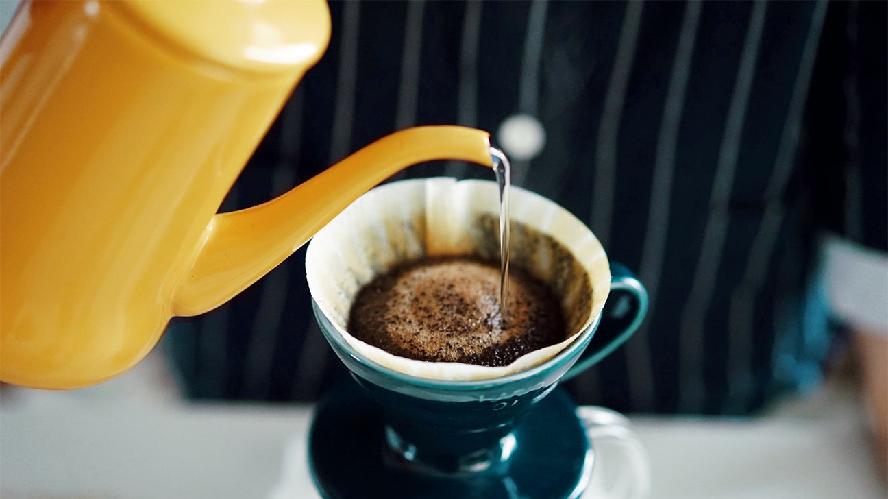 hot water being poured into a filter for a pour-over serving of coffee