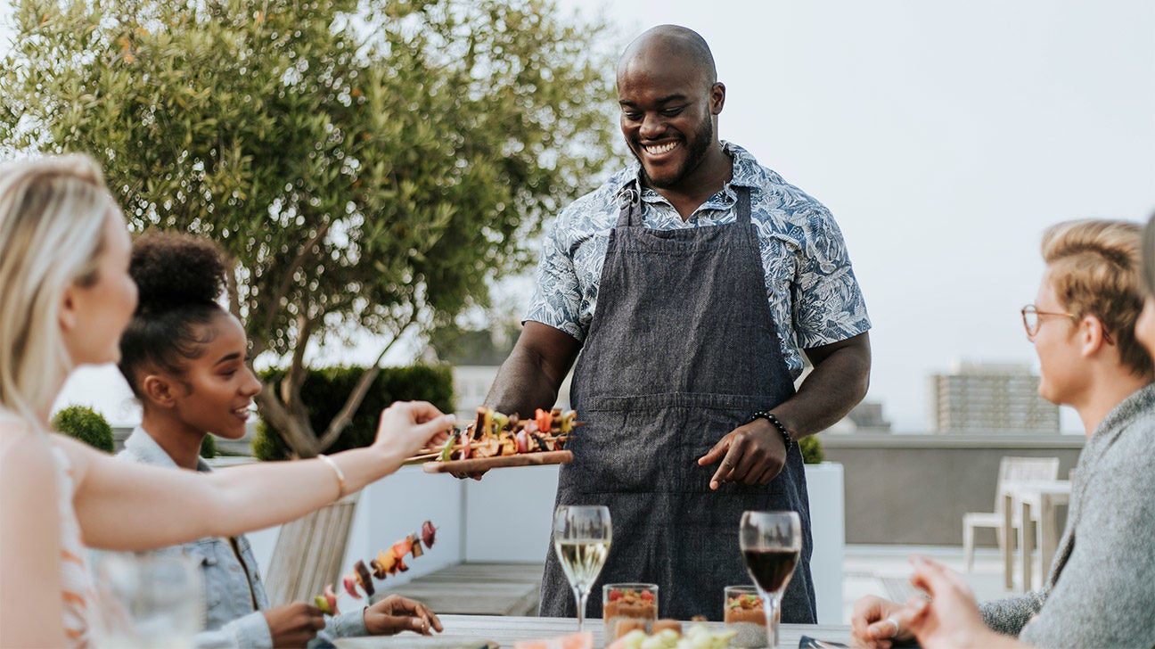 Man serving food to others at a table.