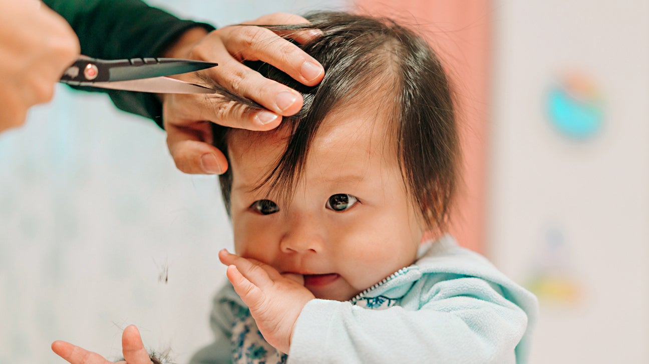 Portrait Of A Young Girl Getting Her Hair Cut In Beauty Hair Salon. Womans  Hand With Hairdressing Scissors. Little Child Is Getting A Haircut In Home  During The Lockdown. Stock Photo, Picture
