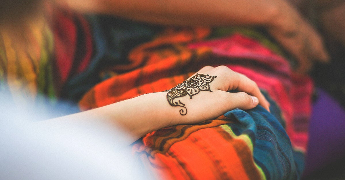 Free Photo  Females hand with a henna tattoo holding a tree with the  beautiful cityscape