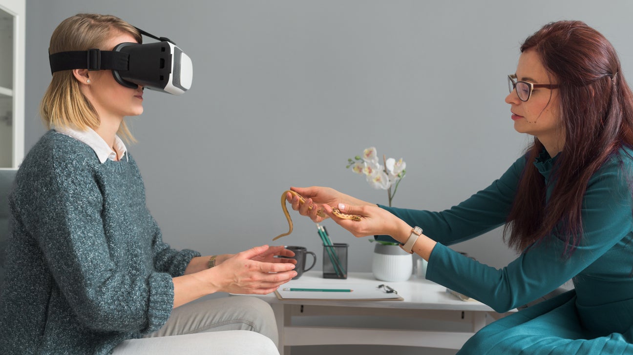  Therapist guiding a patient through exposure therapy using a virtual reality headset.