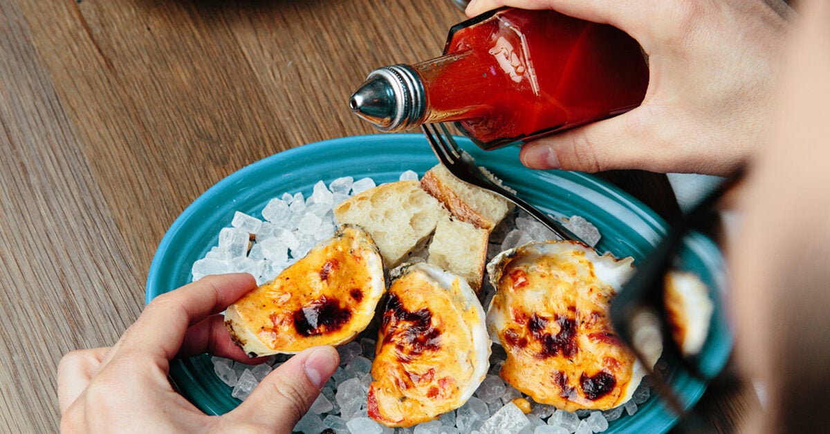 Sriracha Nutrition Benefits Downsides   Pouring Siracha On Baked Oysters 1200 628 Facebook 1200x628 