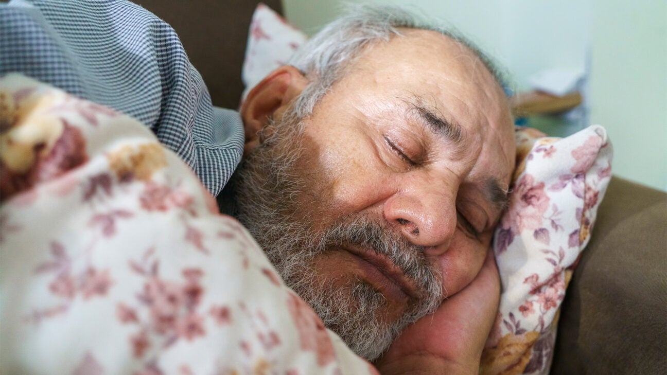 An older man sleeps comfortably