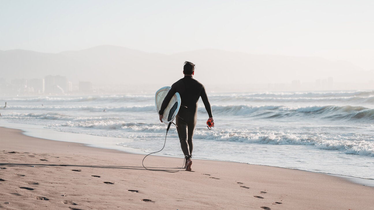 A surfer enjoys the ambiance along a serene beach