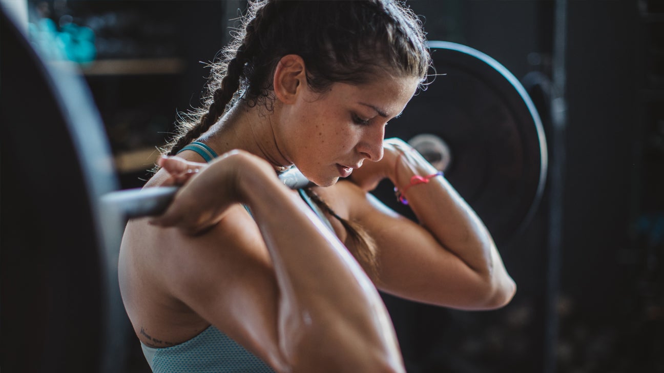 A woman prepares to lift weights.