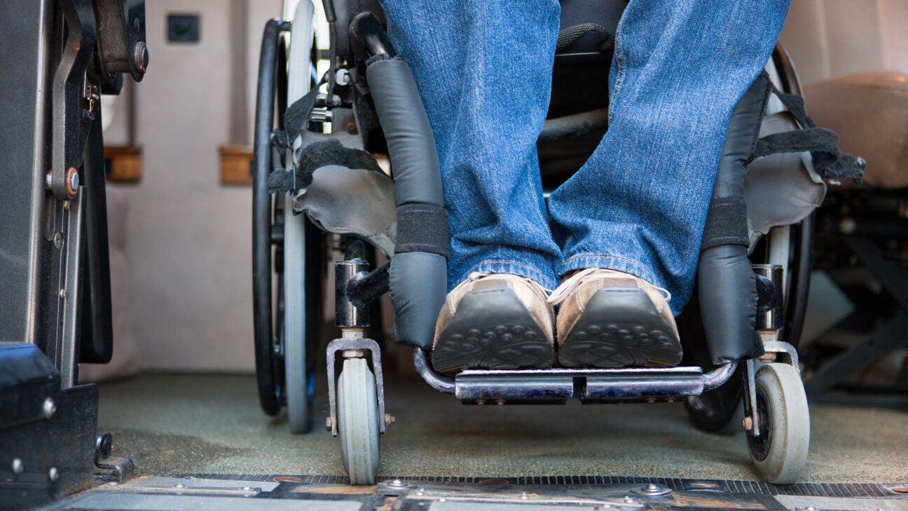 A person rests their two feet at the bottom of a wheelchair