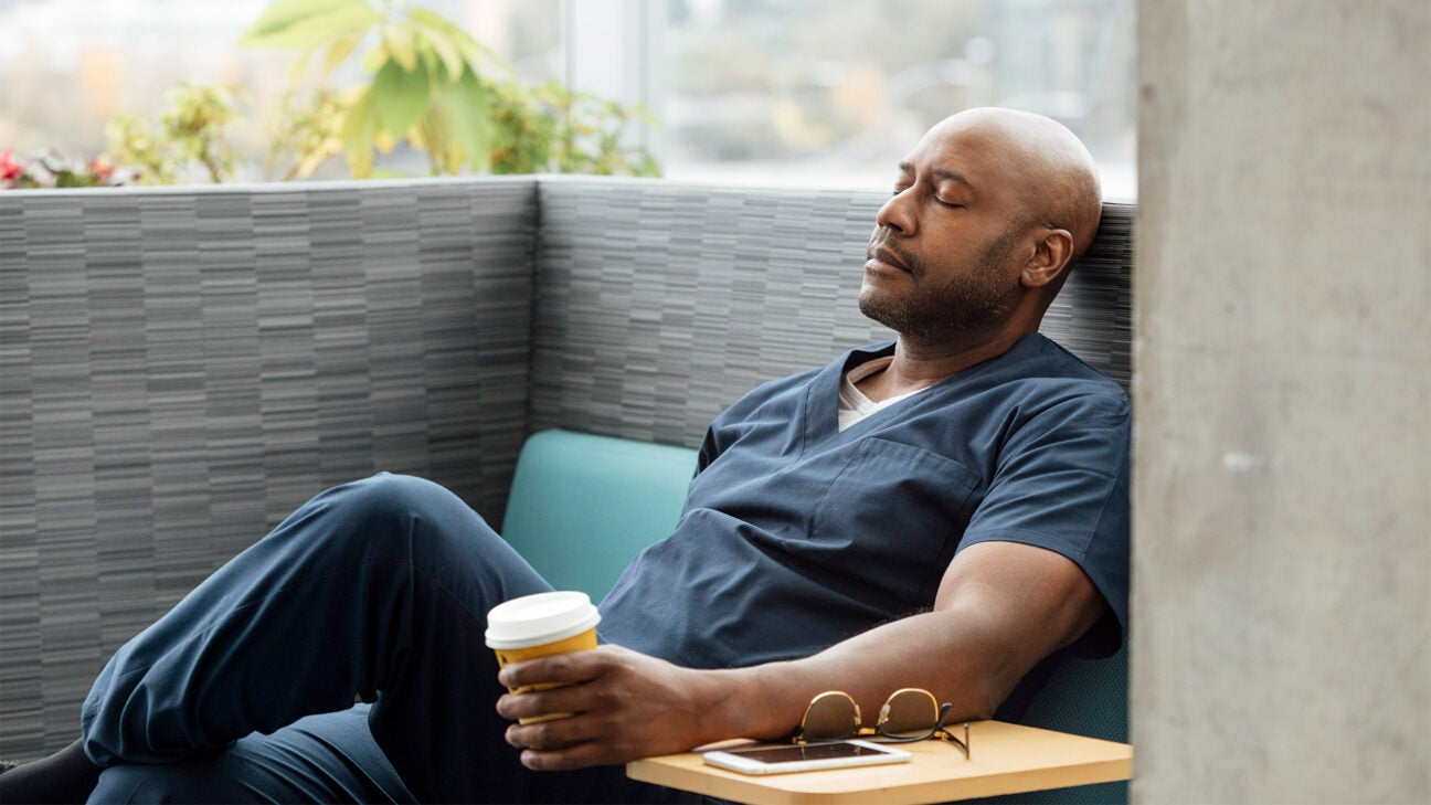 A man closes his eyes while he rests on a couch