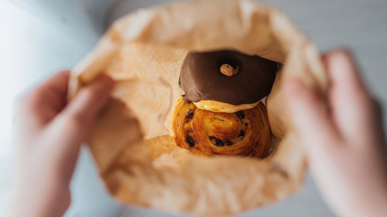 A danish and a doughnut inside a brown paper bag