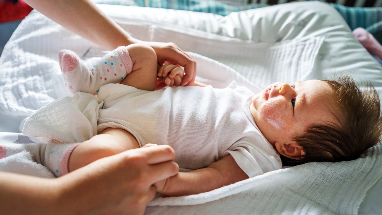 An infant is seen with their caregiver.