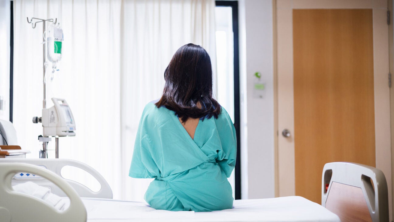 Rear view of a female on a hospital bed wearing a gown