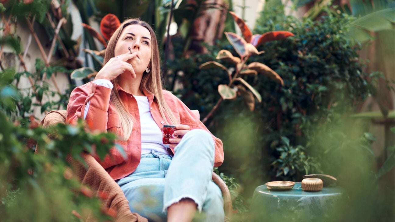 A female smoking a joint with cannabis outdoors