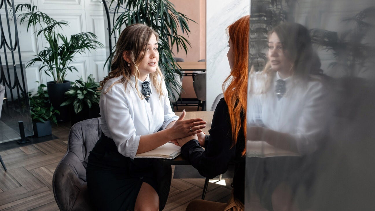 A therapist and a young woman have a serious conversation in an office