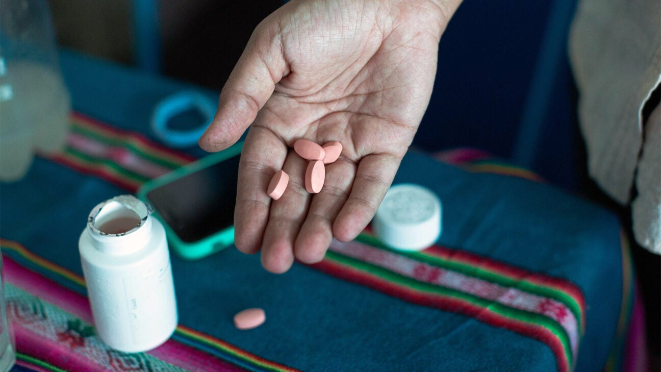 A person holding medication in their hand. 