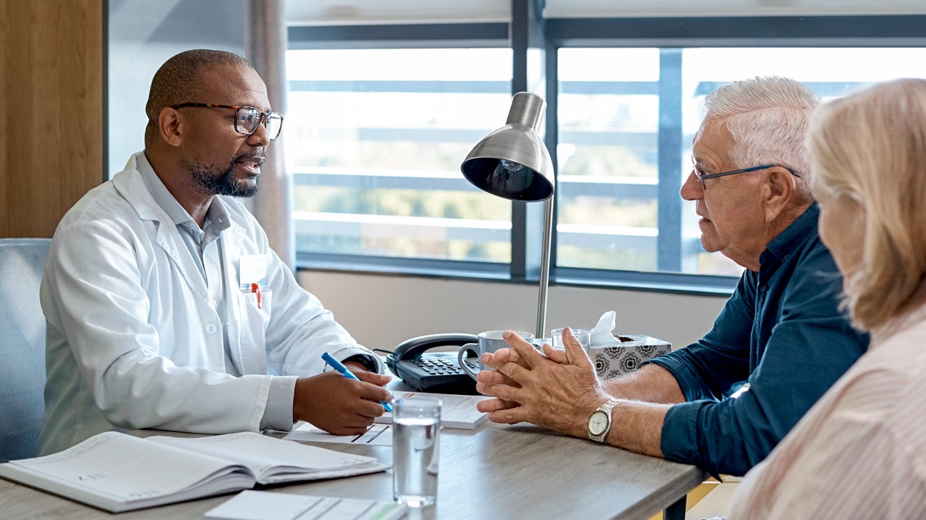 A doctor speaks with an older couple