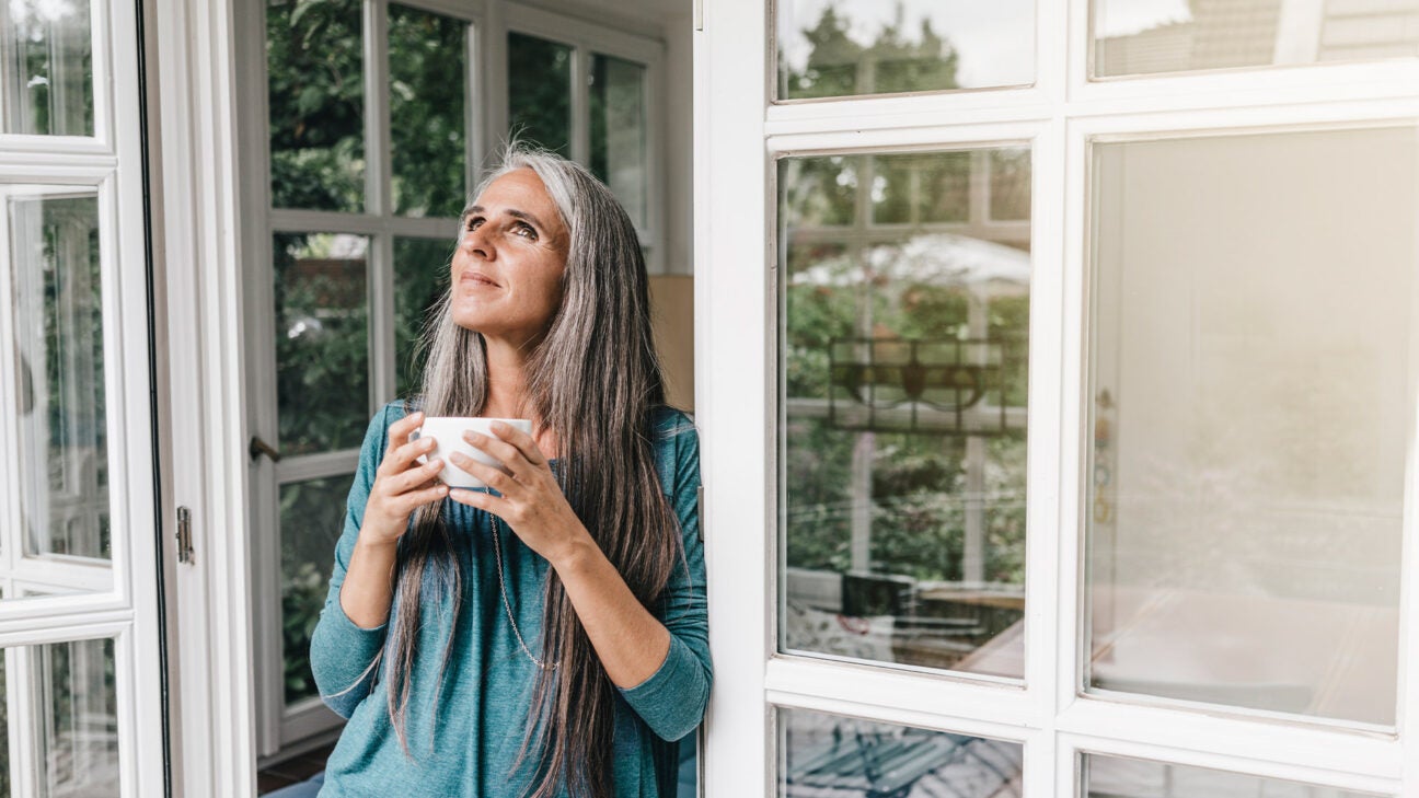 A woman drinking from a cup.