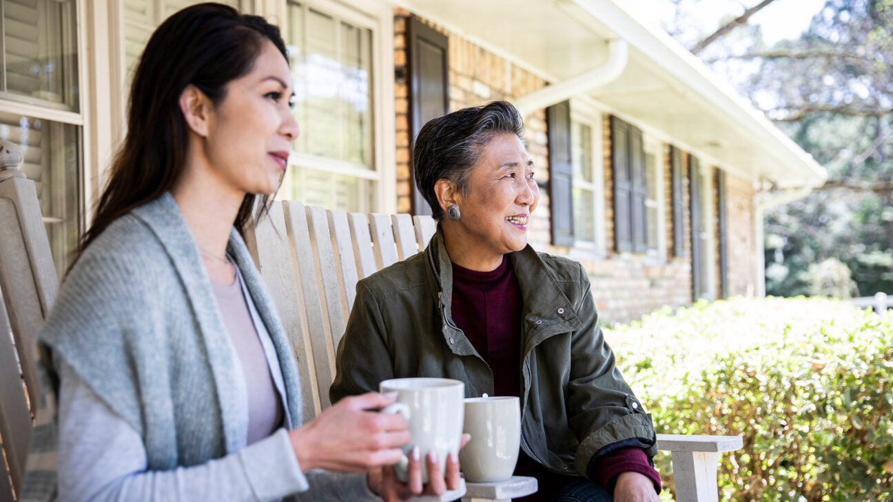 Two women sitting on a porch.