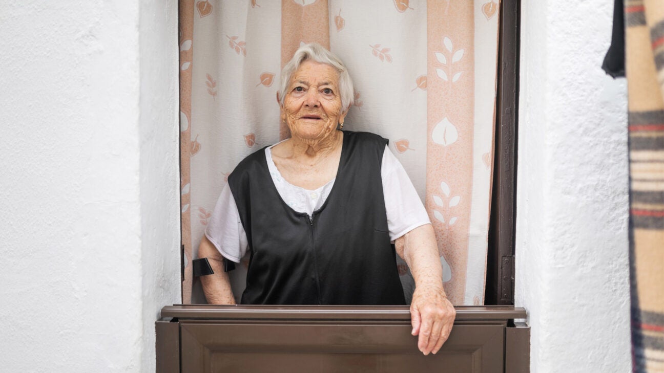 A woman looking out a door.