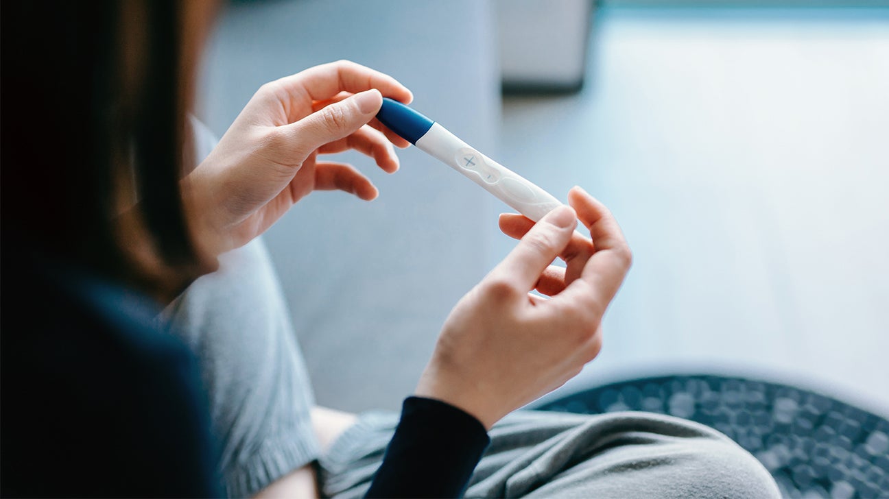 A women carefully checks a pregnancy test