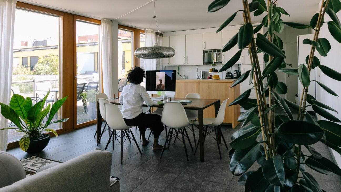 A woman consults with a doctor via computer in her living room