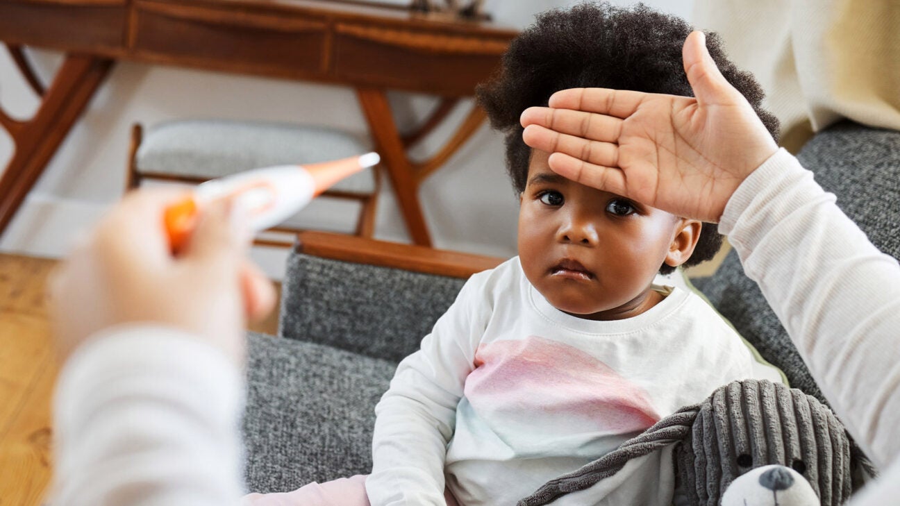 A parent checks an infant's temperature.