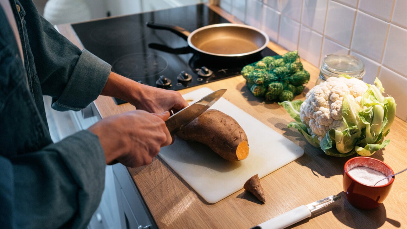 A person prepares a sweet potato for a meal.