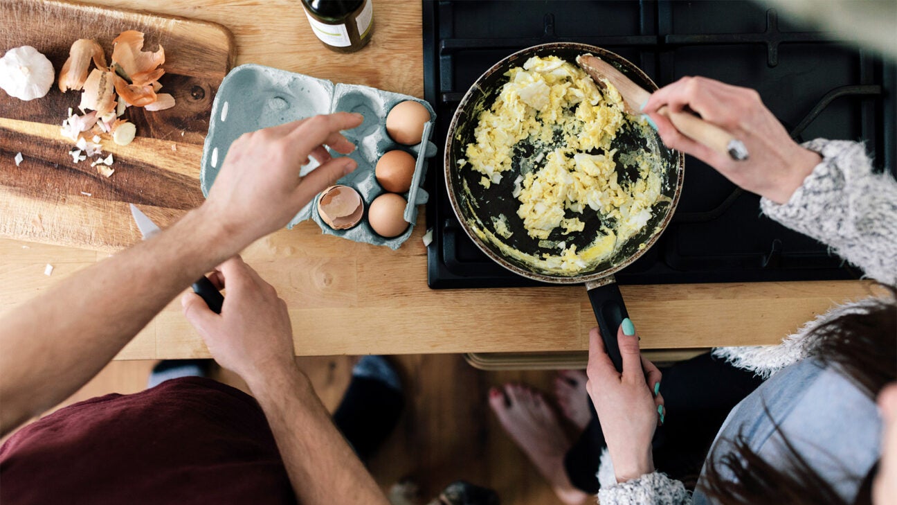 Two people preparing food in a kitchen.