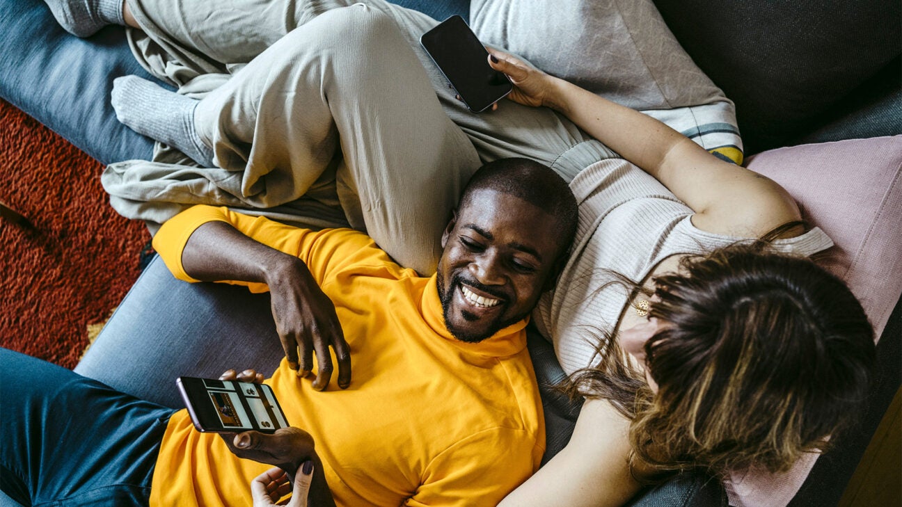 A couple lying on a couch.