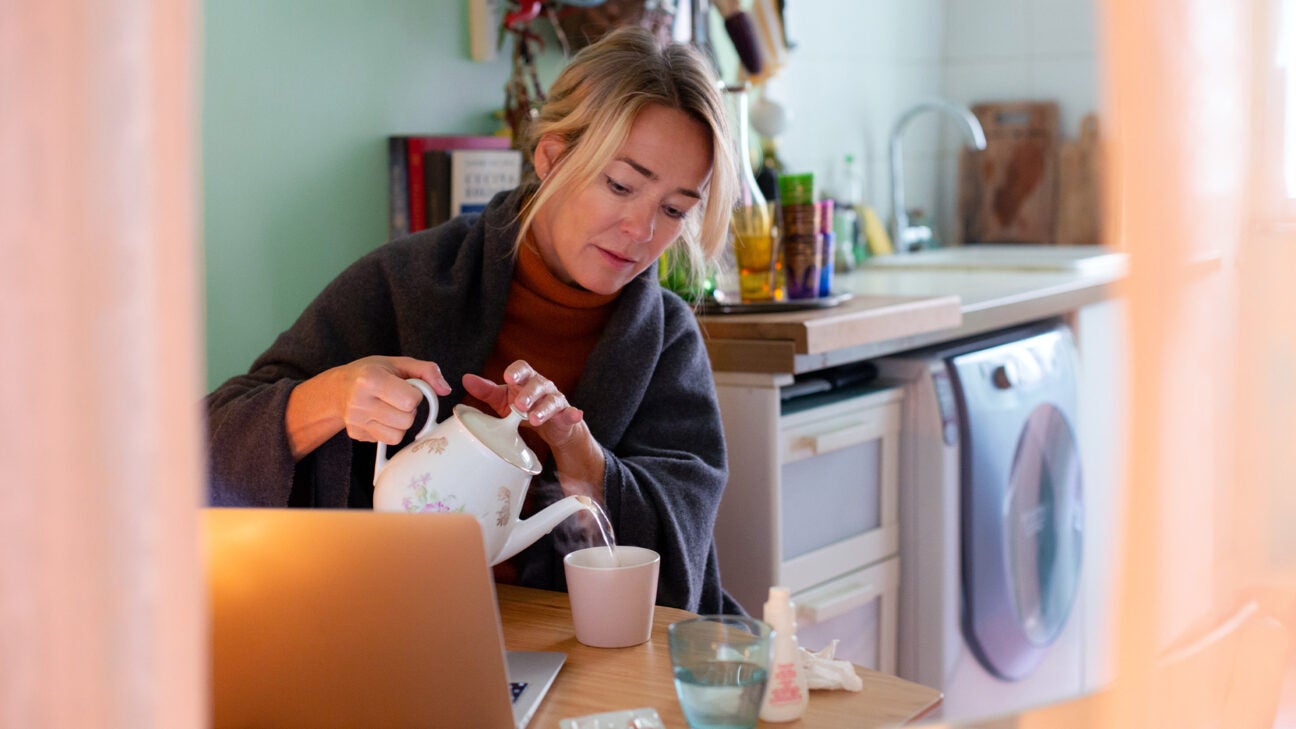 A woman pouring water in a cup.