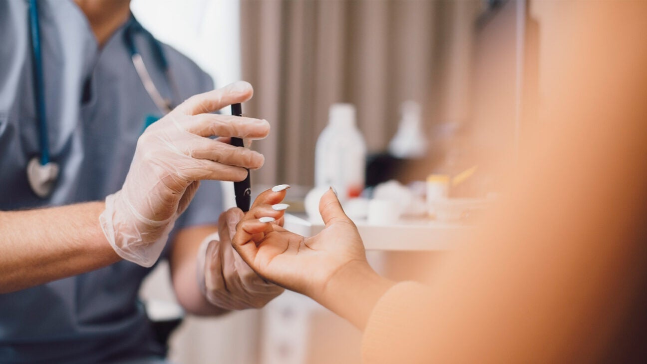 A person gets their blood sugar checked by a healthcare provider.