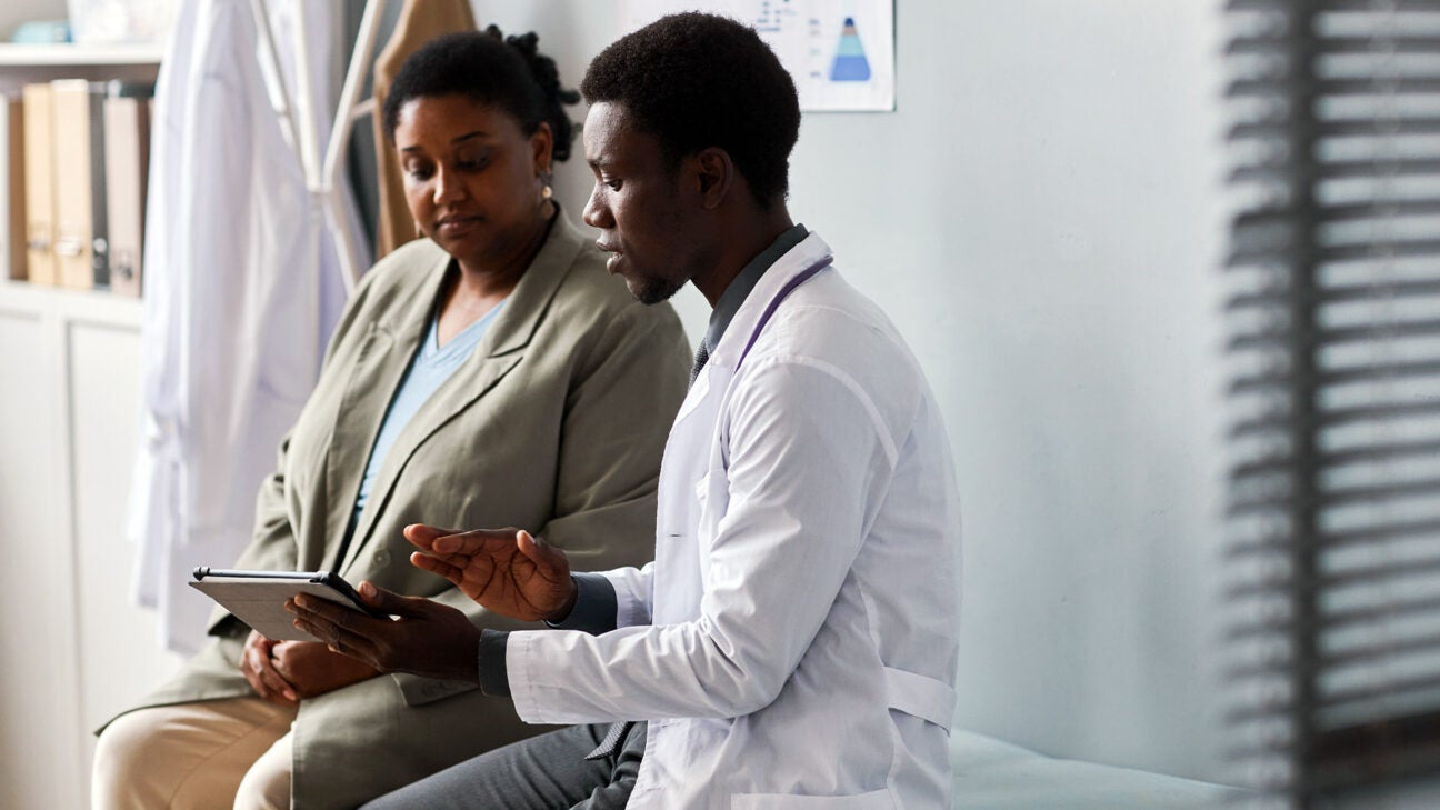 A doctor talks to a female patient in an examing room