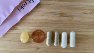 Pills from the Second Trimester Pack lined up next to a penny for size comparison