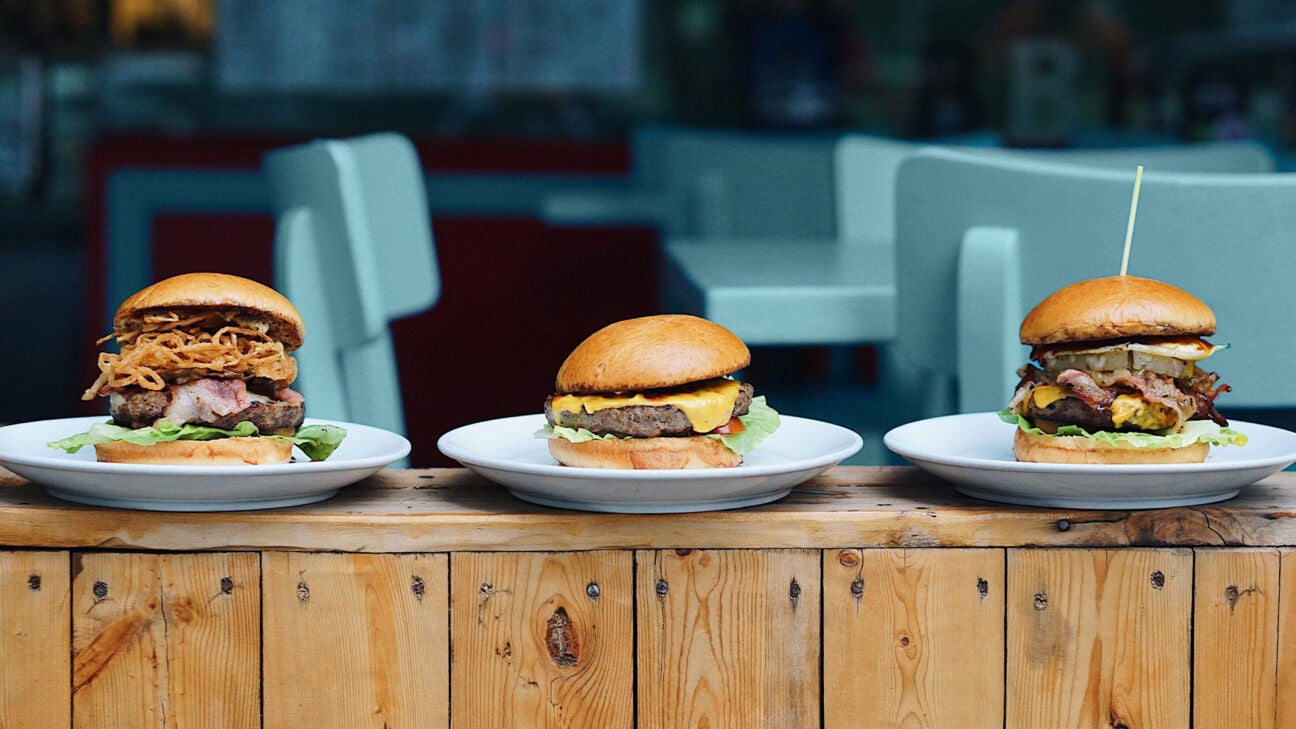 Three hamburgers on plates.