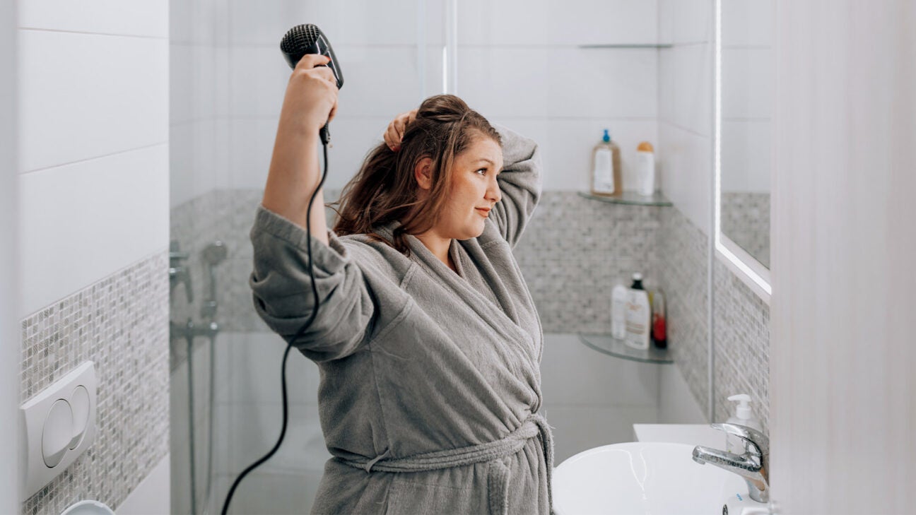 A woman using a blow dryer. 