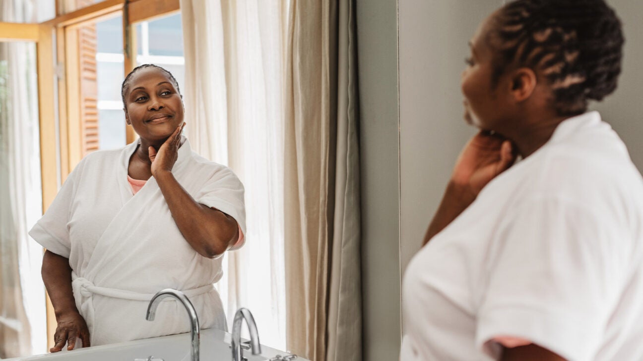 A woman looking in mirror.