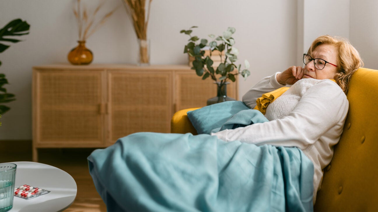 A woman is seen sick on a sofa.