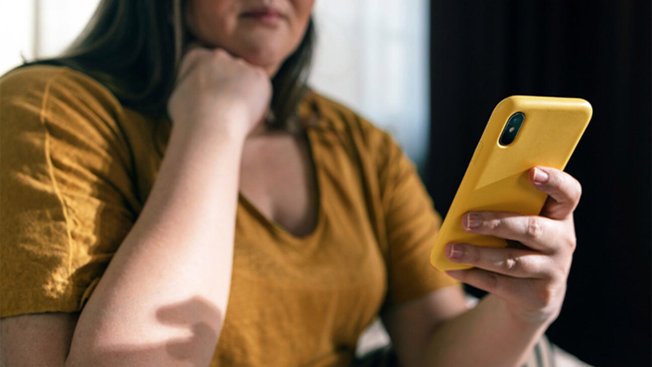 A woman is seen looking at her phone.