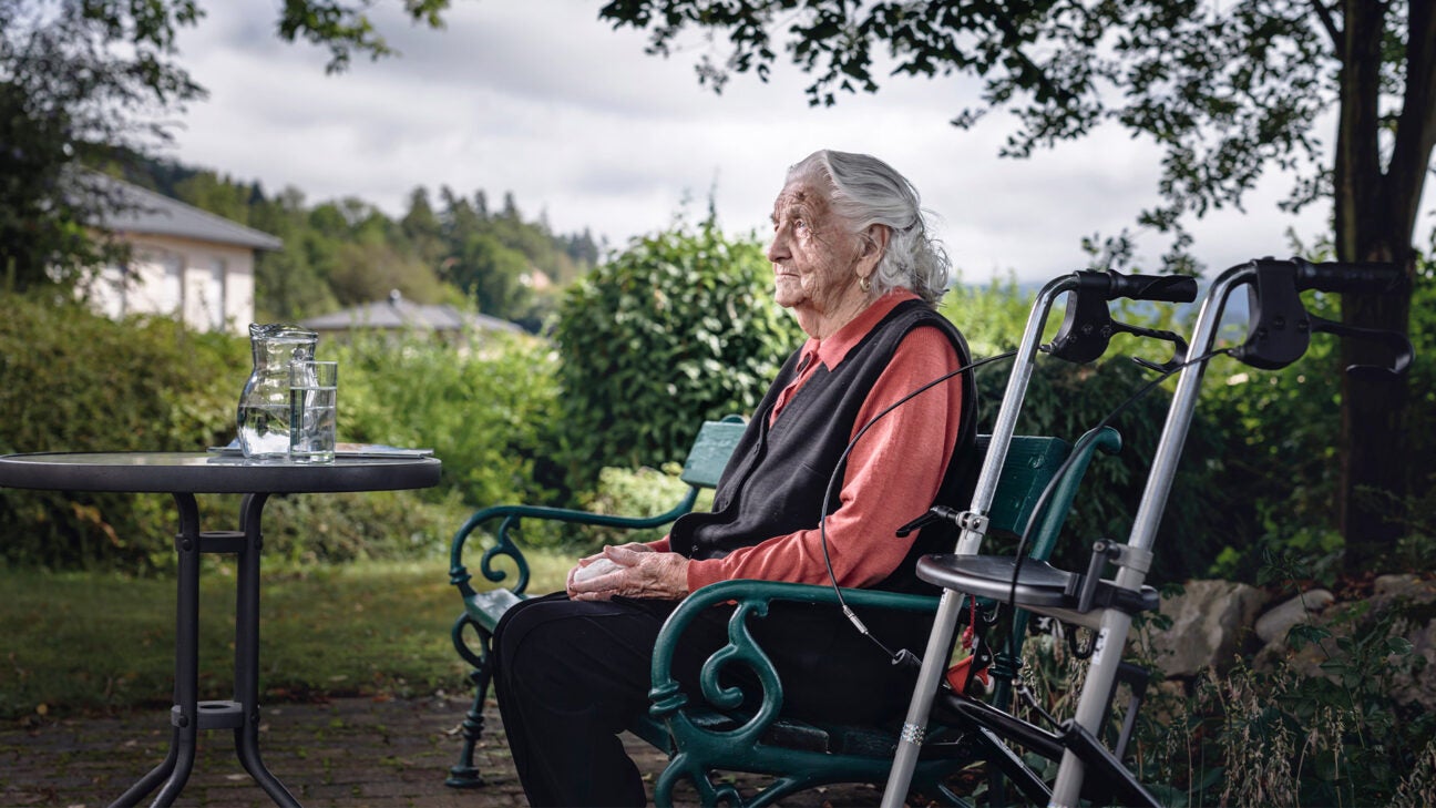 A woman sitting in a wheelchair outside.