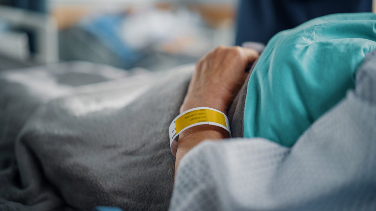 A person is seen laying in a hospital bed.