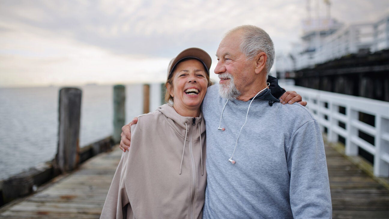 Two people walking along a dock. 