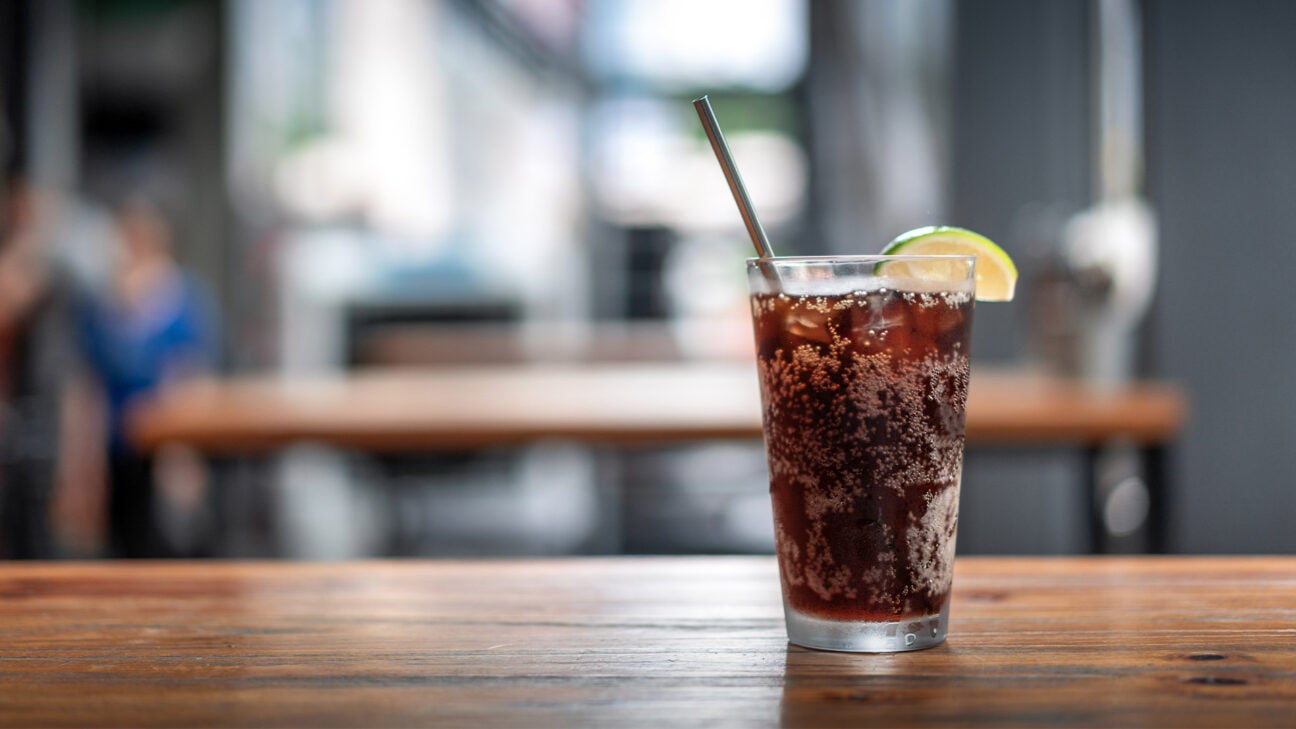 A soda is seen on a table.