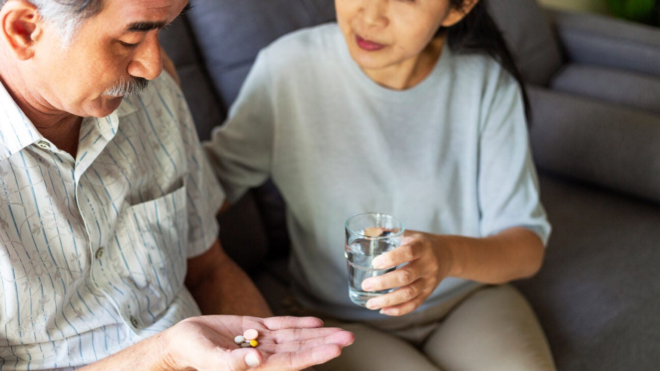 A man holds pills in his hand.